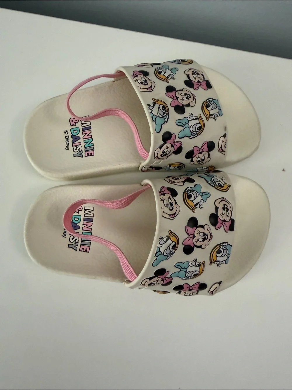white slides feature a colorful Minnie Mouse and Daisy Duck character size 7t